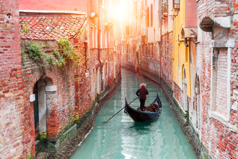 Venetian,Gondolier,Punting,Gondola,Through,Green,Canal,Waters,Of,Venice